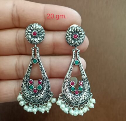 a hand holding a pair of earrings